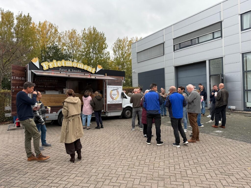 Huurders in gesprek bij de frietwagen achter Verzamelgebouw Reeuwijk